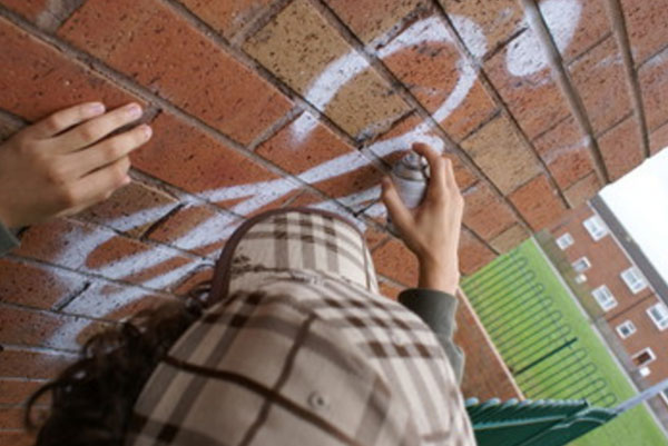 Подросток расписывает стену