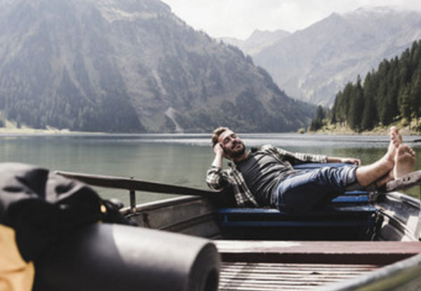 Счастливый мужчина лежит в лодке