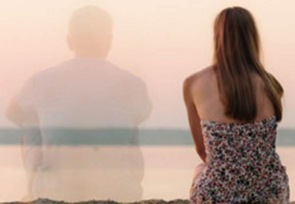 Девушка сидит на берегу. Рядом с ней прозрачный силуэт парня