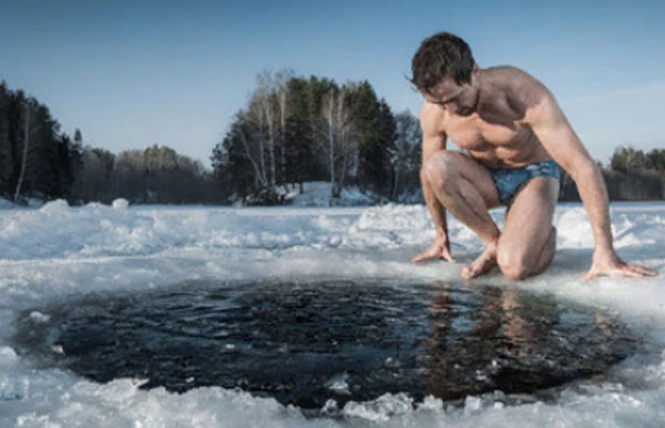 Мужчина в трусах сидит возле проруби