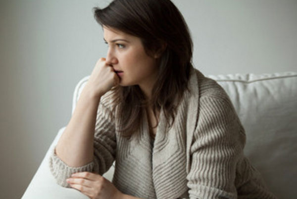 Женщина сидит на кровати. Она вся на нервах