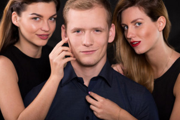 Мужчина, окружен с двух сторон девушками
