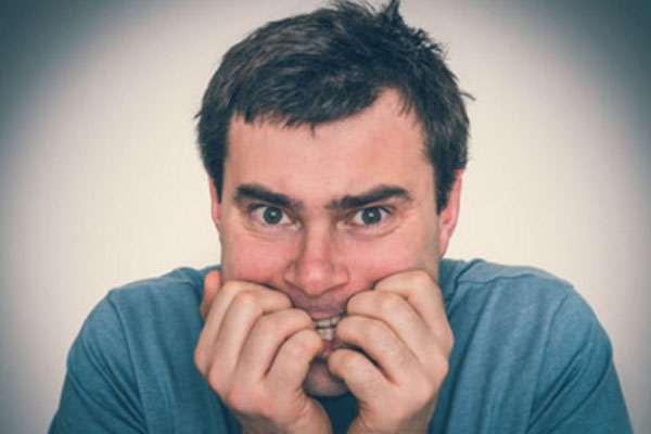 Мужчина чего-то боится, грызет ногти