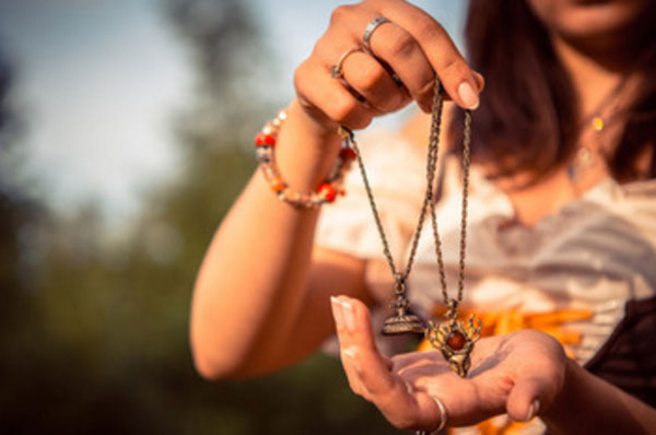 Женщина держит в руке свои амулеты