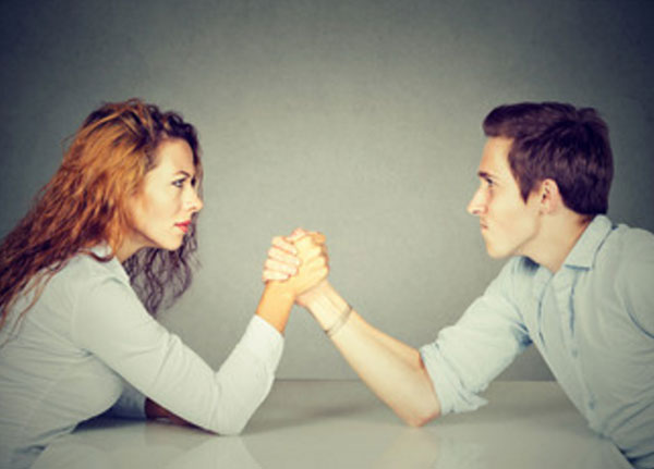 Мужчина а женщина борется на руках